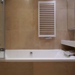 Projekt łazienki w piaskowych kolorach - Grzejnik Instal Projekt Modo, Płytki Marazzi w połączeniu z umywalką z konglomeratu i oświetleniem Aquaform nadają łazience luksusowy wygląd.