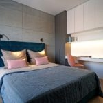 Przytulna sypialnia w nasyconych spójnych kolorach z szafą w welurze od Tap Studio, tapicerowane zielone łóżko i nowoczesna ściana z betonu. To wszystko sprawia, że sypialnia sprzyja relaksowi i wyciszeniu. Projekt Hanna Pietras Pracownia Architektoniczna.